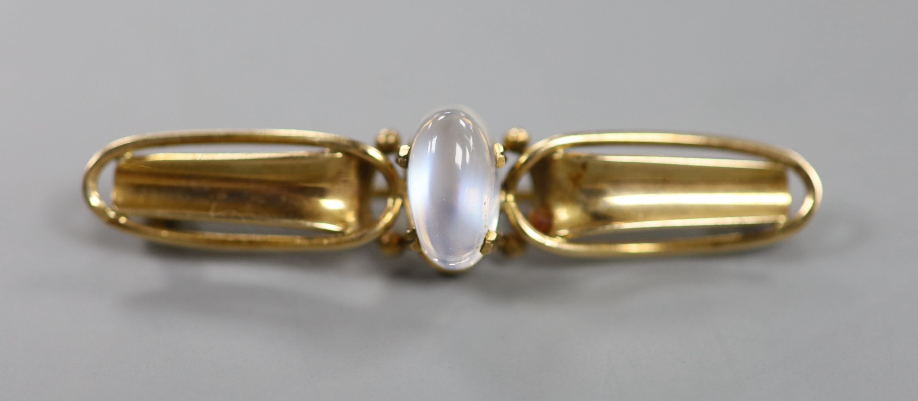 An early 20th century Arts & Crafts 9ct and cabochon moonstone set bar brooch, 47mm, gross weight 3.7 grams.